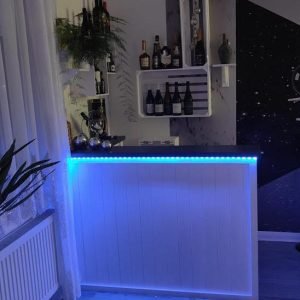 Evening entertaining corner with glowing LED lights on Lumi Slate White Martini 140x80 L-shape home bar