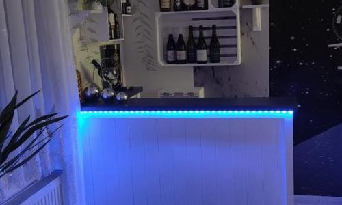Evening entertaining corner with glowing LED lights on Lumi Slate White Martini 140x80 L-shape home bar